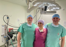 Trzy osoby w strojach medycznych na sali operacyjnej