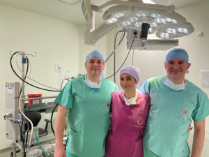 Trzy osoby w strojach medycznych na sali operacyjnej