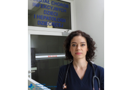 dr Anna Rzucidło-Hymczak na tle szklanych drzwi z nazwą oddziału