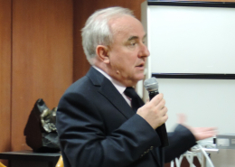 Na zdjęciu kolorowym prof. Rafał Drwiła z mikrofonem, przemawia