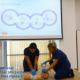 Pracownicy szpitala prezentują przeprowadzanie pierwszej pomocy na manekinie na ekranie widoczny łańczuch przeżycia