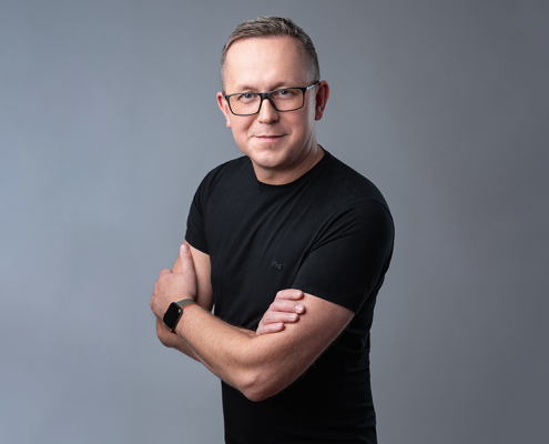 rat. med. Michał Kaleta w czarnej bluzce na szarym tle