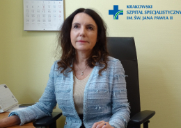 Na kolorowym zdjęciu siedząca przy biurku prof. dr hab. n. med. Anetta Undas