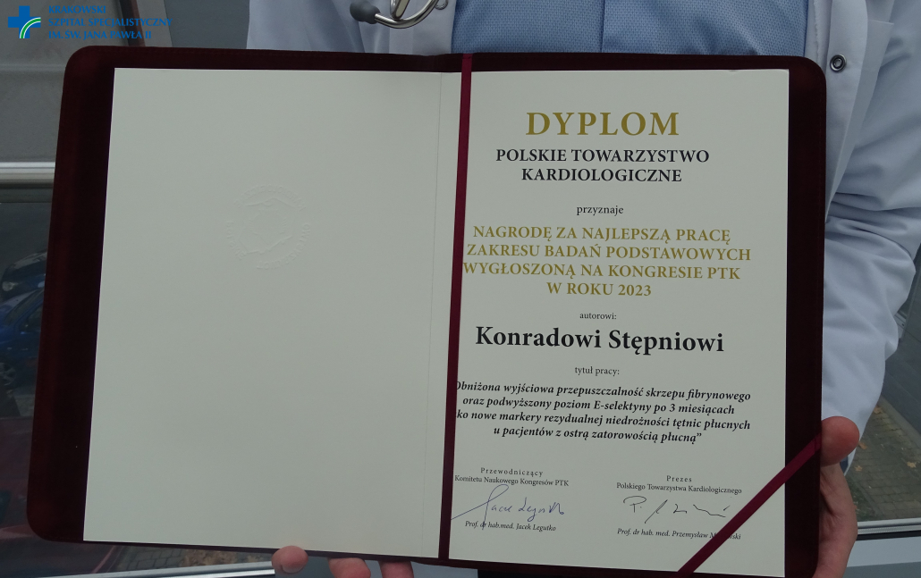 Dyplom w teczce prezentowany w dłoniach przez dr Stępnia