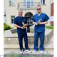 Prof. Gajos i prof. Kopeć ze statuetkami na tle fontanny w medycznych strojach.