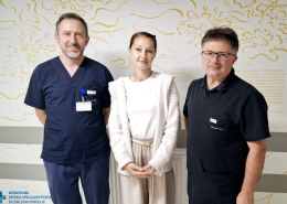 Zdjęcie pacjentki z dwoma lekarzami na szpitalnym oddziale.