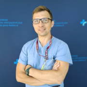 T. Fioka na tle szpitalnych logotypów.