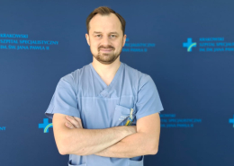Dr P. Szolc na tle szpitalnych logotypów.