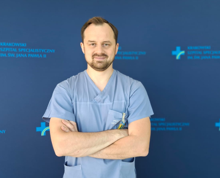 Dr P. Szolc na tle szpitalnych logotypów.