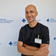 Dr Wasilewski w stroju medycznym na białym tle.