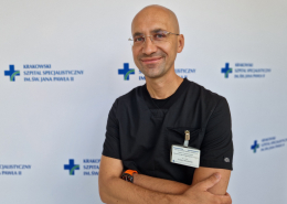 Dr Wasilewski w stroju medycznym na białym tle.