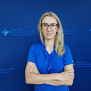 U. Gabcarczyk w niebieskim stroju medycznym.