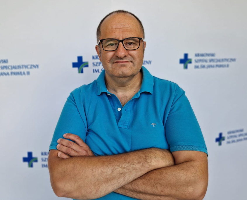 Kolorowe zdjęcie prof. Wierzbickiego na tle białym z logotypami szpitala.