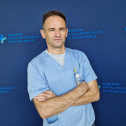 mgr Zdzisław Gruca w medycznym ubraniu na granatowym tle