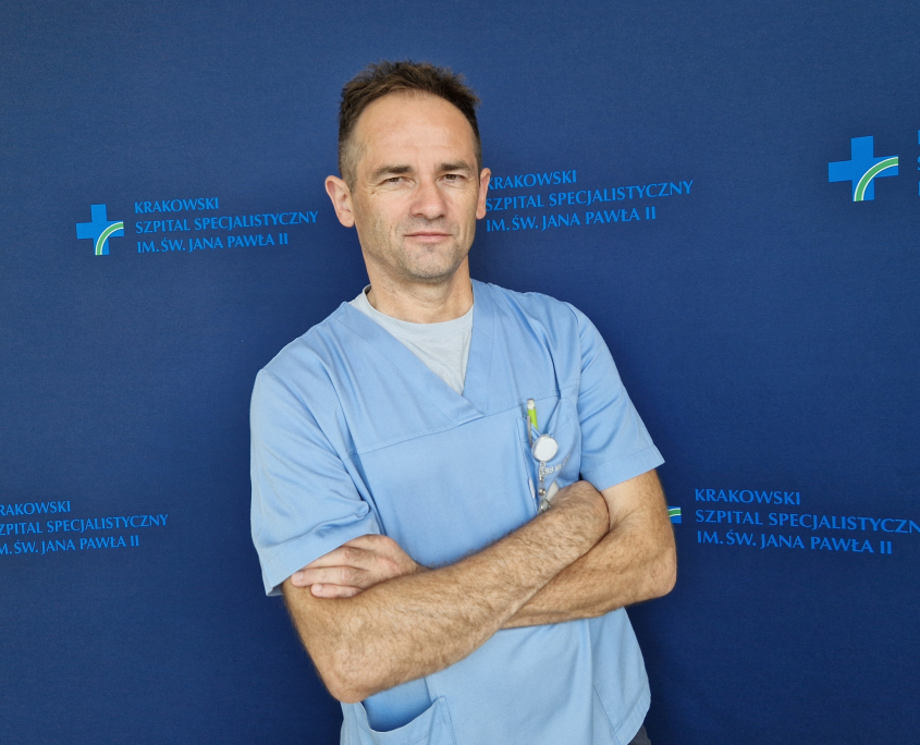 mgr Zdzisław Gruca w medycznym ubraniu na granatowym tle