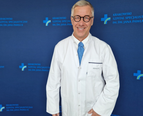 prof. dr hab. n. med. Grzegorz Gajos w medycznym ubraniu na granatowym tle