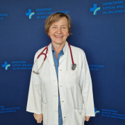 dr n. med. Urszula Czubek w medycznym ubraniu na granatowym tle