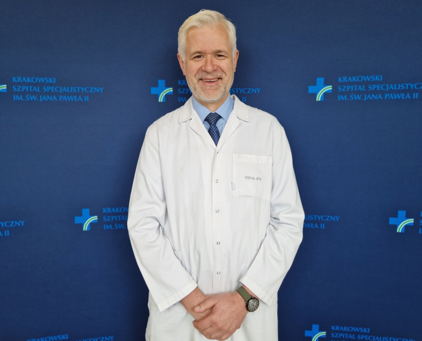 Dr hab. n. med. Andrzej Gackowski w stroju medycznym na granatowym tle