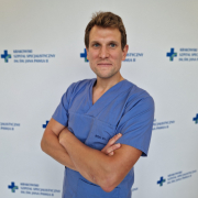 lek. Jakub Drewniak w medycznym ubraniu na białym tle