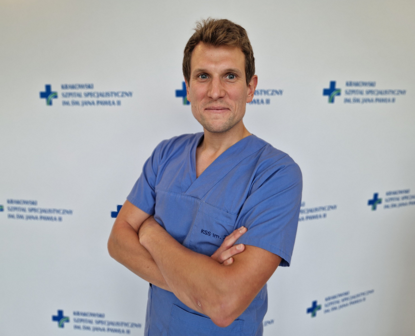 lek. Jakub Drewniak w medycznym ubraniu na białym tle