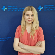 dr n. med. Aleksandra Kułaga na grantowym tle w stroju medycznym