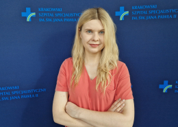 dr n. med. Aleksandra Kułaga na grantowym tle w stroju medycznym