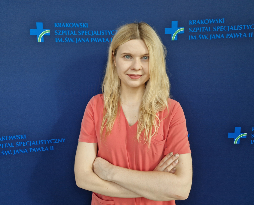 dr n. med. Aleksandra Kułaga na grantowym tle w stroju medycznym