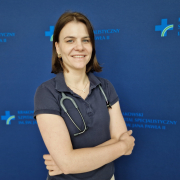 dr n. med. Ewa Dziewięcka na grantowym tle w stroju medycznym