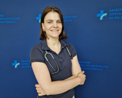 dr n. med. Ewa Dziewięcka na grantowym tle w stroju medycznym