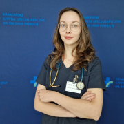 lek. Kseniya Bankrashkova w medycznym ubraniu na granatowym tle