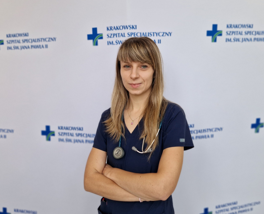 lek. Martyna Sikorska w grantowym ubraniu medycznym na białym tle