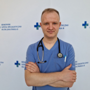 lek. Marcin Jakiel w medycznym ubraniu na białym tle