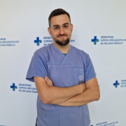 lek. Łukasz Czyż w ubraniu medycznym na białym tle