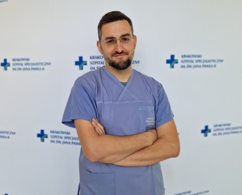 lek. Łukasz Czyż w ubraniu medycznym na białym tle