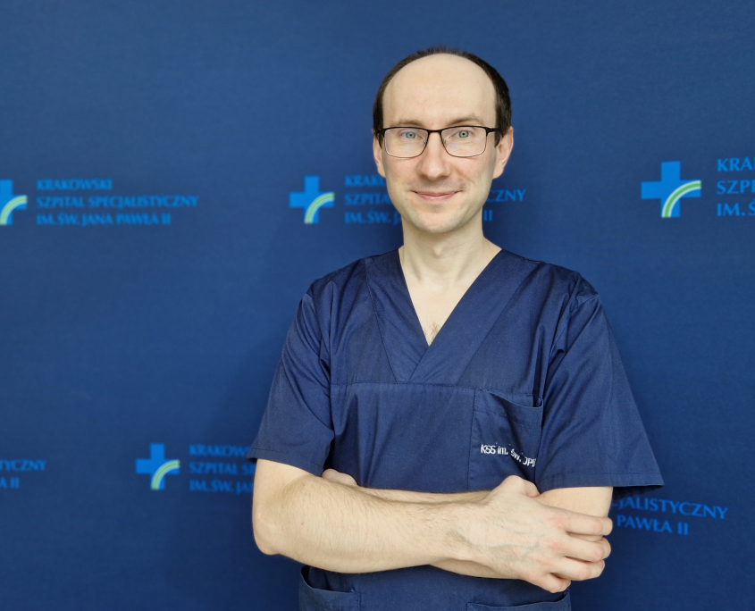 dr n. med. Wojciech Magoń w medyczny ubraniu na granatowym tle