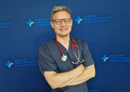 dr n. med. Jakub Stępniewski w medycznym ubraniu na granatowym tle