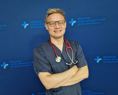 dr n. med. Jakub Stępniewski w medycznym ubraniu na granatowym tle