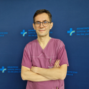 dr n. med. Jarosław Trębacz w medycznym ubraniu na granatowym tle