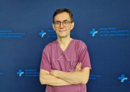 dr n. med. Jarosław Trębacz w medycznym ubraniu na granatowym tle