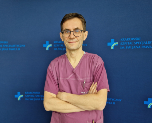 dr n. med. Jarosław Trębacz w medycznym ubraniu na granatowym tle