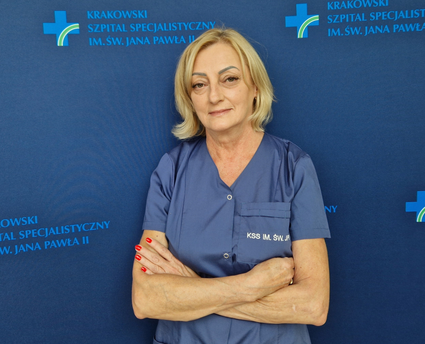 Małgorzata Wołoch w medycznym ubraniu na granatowym tle