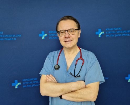 prof. dr hab. n. med. Paweł Rubiś w medycznym ubraniu na grantowym tle