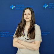 lek. Anna Maciak-Pawłucka w medycznym ubraniu na granatowym tle