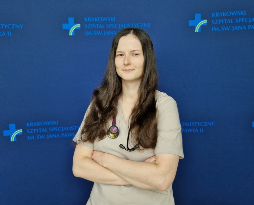 lek. Anna Maciak-Pawłucka w medycznym ubraniu na granatowym tle