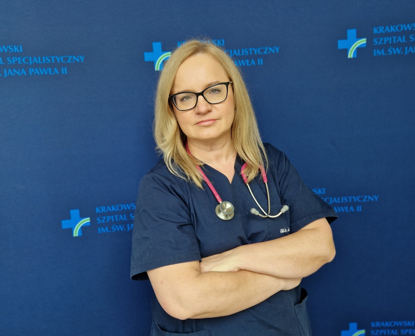 dr n. med. Magdalena Kaźnica-Wiatr w medycznym ubraniu na granatowym tle