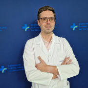 dr n. med. Grzegorz Karkowski w białym ubraniu na granatowym tle