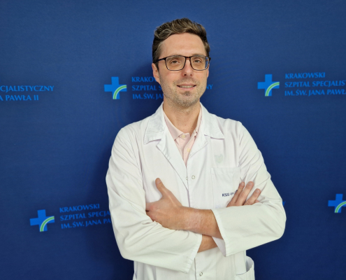 dr n. med. Grzegorz Karkowski w białym ubraniu na granatowym tle
