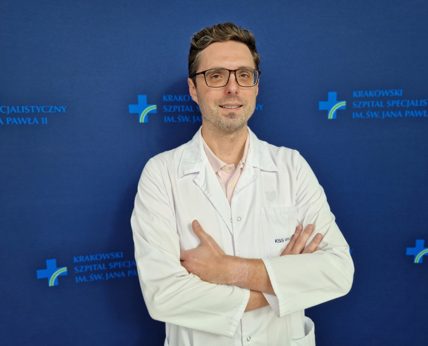 dr n. med. Grzegorz Karkowski w białym ubraniu na granatowym tle