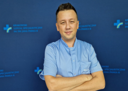 mgr Tomasz Sprzyp w medycznym ubraniu na granatowym tle