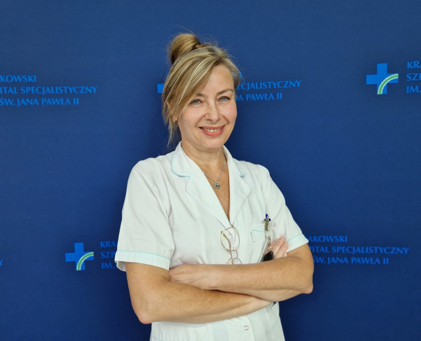 mgr Bożena Fijałkiewicz w medycznym ubraniu na granatowym tle